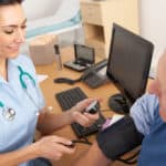 British nurse taking senior man's blood pressure